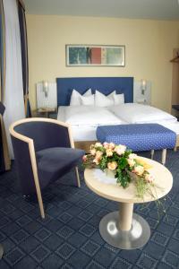 a hotel room with a bed and a table and a chair at Hotel Löwen-Seckenheim in Mannheim