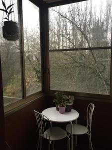 un tavolo e sedie in una stanza con due finestre di Casa Vacanze Orchidea CIR0347AT00249 a Parma Altre 9 foto