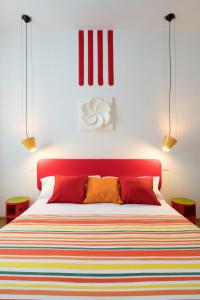 una camera da letto con un letto con una coperta colorata a righe di Zip b&b . design in Florence a Firenze