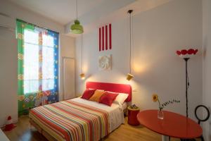 a bedroom with a bed with a red headboard and a table at Zip b&b . design in Florence in Florence