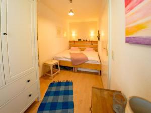 ein kleines Schlafzimmer mit einem Bett und einem blauen Teppich in der Unterkunft Wohlfühloase am Weißen Hirsch in Dresden