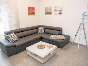 - un salon avec un canapé en cuir et une table dans l'établissement Haus "Jasmund" in Sellin - WG01 im EG mit Kamin und Terrasse, à Sellin