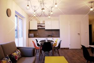 a living room and kitchen with a table and chairs at Obiekt Noclegowy OCELOT in Pruszków