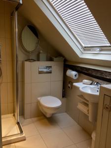 La salle de bains est pourvue de toilettes, d'un lavabo et d'un miroir. dans l'établissement Waterside Cottage Bed and Breakfast, à Knaresborough