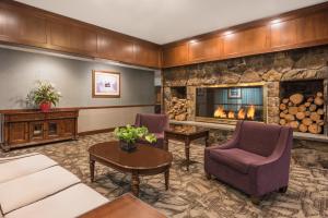 
a living room filled with furniture and a fire place at Ramada Plaza by Wyndham Portland in Portland
