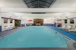 
a swimming pool with a pool table and chairs at Ramada Plaza by Wyndham Portland in Portland
