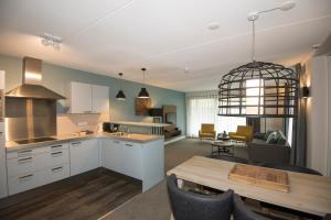 a kitchen and living room with a table and a dining room at Vlierijck in Oost-Vlieland