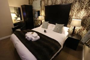 a hotel room with a large bed and a large mirror at Woodlands in Windermere