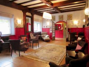 a living room filled with furniture and red cabinets at Logis Hôtel des Causses in Millau