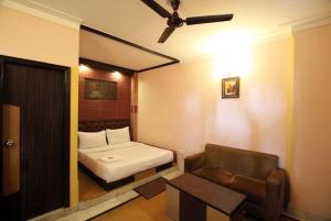ein kleines Zimmer mit einem Bett und einem Sofa in der Unterkunft Hotel Traditional Inn in Neu-Delhi