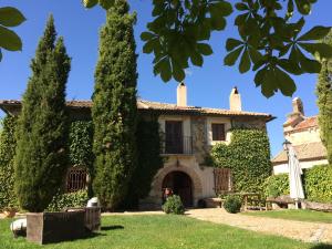 uma casa velha com árvores em frente em Exclusiva Casa Rustica em Pelayos del Arroyo