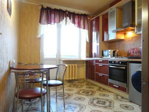 a kitchen with a table and chairs and a window at Inndays on 9 Maya in Tula