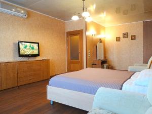 a bedroom with a bed and a flat screen tv at Inndays on 9 Maya in Tula