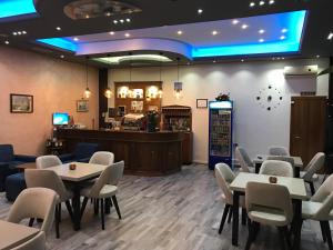 a restaurant with tables and chairs and a bar at Hotel Jurgen in Lezhë