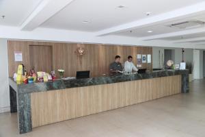 two men standing at a counter in a lobby at Real Classic Bahia Hotel in Salvador