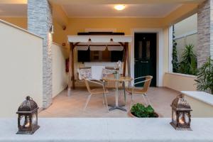 a patio with a table and chairs and an umbrella at Azalea in Vasiliki