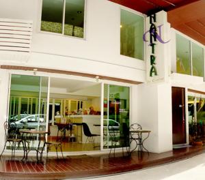 a restaurant with chairs and tables in front of a building at Nantra de Comfort in Bangkok