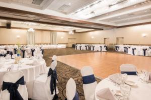 a banquet hall with white tables and white chairs at Ramada Plaza by Wyndham Portland in Portland