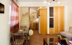 a living room with a dining room table and a kitchen at Azalea in Vasiliki