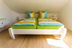 1 cama blanca con almohadas coloridas en una habitación en Harzer Auszeit en Hattorf