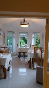 a dining room with tables and chairs and a chandelier at Eastdale Bed and Breakfast in North Ferriby