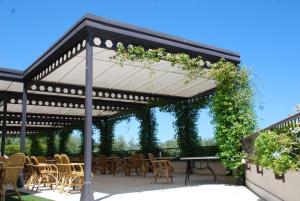 a pergola with chairs and tables under it at Villa Maria Hotel & SPA in Francavilla al Mare