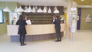 a group of people standing at a reception counter at Résidence Séniors Domitys Les Hautes Feuilles in Reims +17 photos