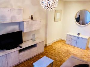 a living room with a television and a mirror at Apartamento Vitoria II in Vitoria-Gasteiz