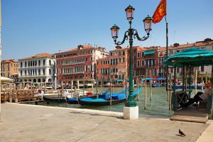 a street light next to a canal with boats at Palazzo Bembo - Exclusive Accommodation in Venice