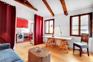 a living room with a table and red curtains at Bragora Smoochy Attic In Venice in Venice