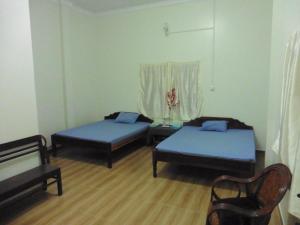 SunRise Villa في كامبونغ تشام: غرفة نوم بسريرين وطاولة ونافذة