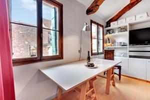una cucina con tavolo bianco e TV di Bragora Smoochy Attic In Venice a Venezia Altre 7 foto