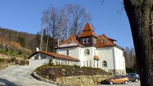 uma grande casa branca com um telhado castanho em Pałacyk Szklarska em Piechowice