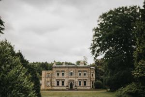 uma velha casa de pedra no meio de um campo em Cleatham Hall em Manton