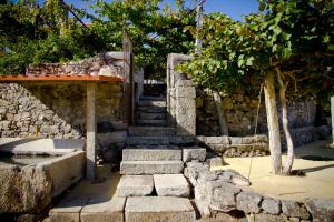 a stone building with stairs and a stone wall at Casa na Quinta de Valinhas in Vitorino dos Piães