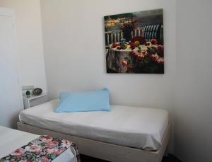 トロペアにあるMini Appartamento Tropea centro "Triangolo al Tondo" vista mareのベッドが2つあり、壁に絵が飾られた寝室