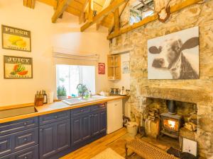 a kitchen with a fireplace and a stone wall at Glamping Bothie in Inverurie