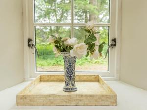 a blue and white vase with white flowers in a window at Glamping Bothie in Inverurie