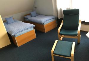a room with two beds and a chair and a chair at Penzion Z&Z in Tábor