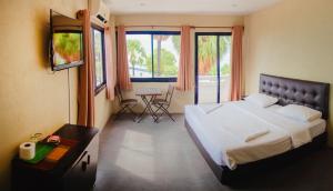 喬木提恩海灘的住宿－GI旅館，一间卧室配有一张大床和一张桌子及椅子