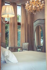 1 dormitorio con cama, espejo y lámpara de araña en Finca Cas Sant en Sóller