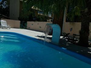 uma piscina azul com uma fonte de água em Pousada Santa Genoveva campeche em Florianópolis