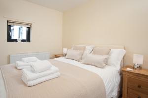 ein weißes Schlafzimmer mit einem großen Bett mit weißen Kissen in der Unterkunft The Counting House in Belford