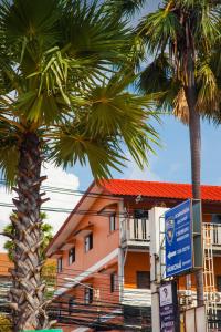 喬木提恩海灘的住宿－GI旅館，两棵棕榈树,在一座有标志的建筑前