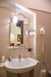 W łazience znajduje się umywalka i lustro. w obiekcie Palmed Hotel w mieście Gizzeria