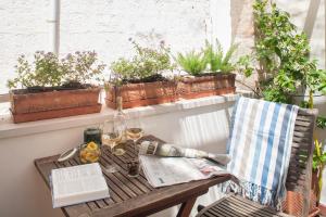 a table on a balcony with a book and glasses of wine at Elena's House 6 in Polignano a Mare