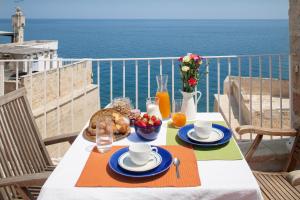 a table with food and a view of the ocean at Elena's House 6 in Polignano a Mare