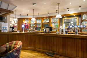 a bar in a pub with a counter and a bar at The Swan by Innkeeper's Collection in Coleshill