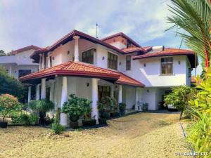 a large white house with a red roof at Ceylon Pearlwing Resort in Negombo