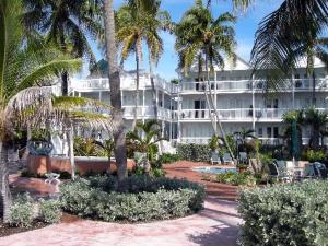 a large white building with palm trees in front of it at Coconut Beach Resort in Key West